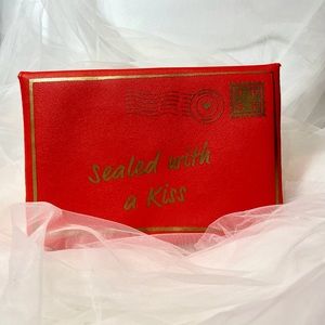 Red and gold SEALED WITH A KISS Ipsy bag.